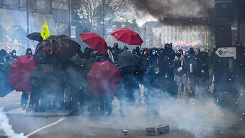 抗议者在法国西部最大城市南特举行的示威活动期间使用雨伞来抵御催泪瓦斯